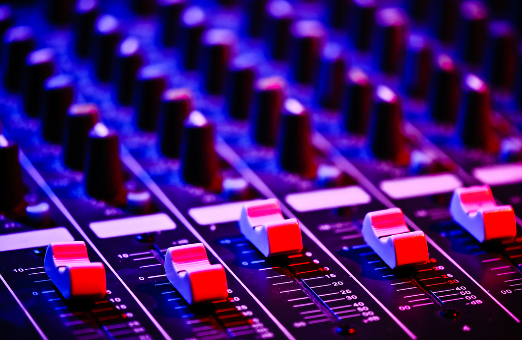 audio mixing board lit by blue and red lights