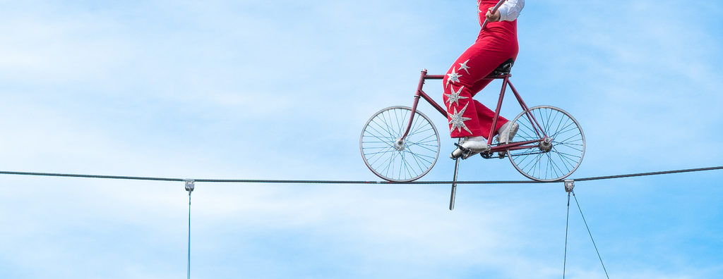 man riding bike on tightrope